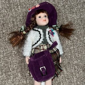 Porcelain doll with purple bag